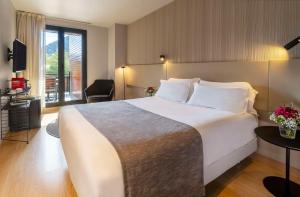 A bed or beds in a room at NH Collection Andorra Palomé