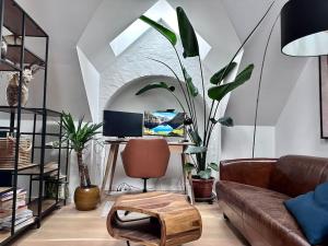 - un salon avec un canapé et un bureau avec un ordinateur dans l'établissement Penthouse: Copenhagen delight, à Copenhague