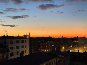 une ligne d'horizon avec le coucher du soleil en arrière-plan dans l'établissement Penthouse: Copenhagen delight, à Copenhague