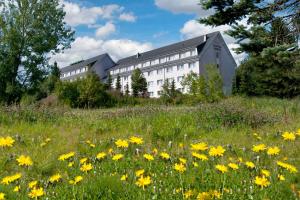 Aparthotel Oberhof في أوبرهوف: مبنى على تل به ميدان من الزهور