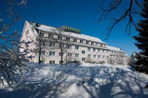 Aparthotel Oberhof في أوبرهوف: مبنى عليه لافته عليه في الثلج