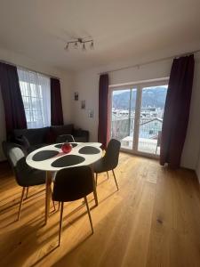 uma sala de estar com uma mesa e cadeiras com vista em CityLake G23 Apartments mit kostenlosem Parkgaragen-Stellplatz !! em Gmunden