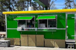 a green food truck with a yellow roof at Stonegate Lodge 2 Queen Beds Fast WiFi 50in TV Salt Water Pool Room # 305 in Eureka Springs