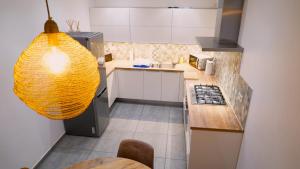 a kitchen with a large yellow light hanging from the ceiling at Maison 3 chambres proximité aéroport et grand axes in Charleroi