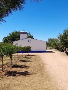 蒙萨拉什Monte do Ribeiro Baço - Monsaraz的一座白色的大建筑,上面有一条蓝色条纹