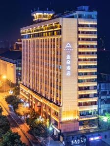 een groot gebouw met 's nachts een bord bij Atour Hotel Chengdu Chunxi Road Tianfu Square Subway Station in Chengdu