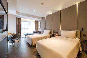 A bed or beds in a room at Atour Hotel Hangzhou Huanglong Wanke Xueyuan Road