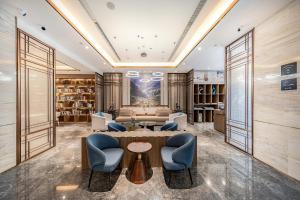 een lobby met een tafel en stoelen en een bibliotheek bij Atour Hotel Chengdu Chunxi Road Tianfu Square Subway Station in Chengdu