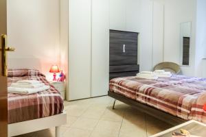 een slaapkamer met 2 bedden en een spiegel bij Appartamento Onda d'argento in Porto Santo Stefano