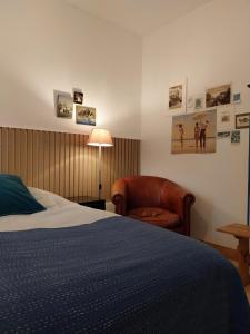 una camera con letto, sedia e lampada di B&B Noordwijk Binnen a Noordwijk