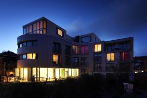 un bâtiment avec ses lumières allumées la nuit dans l'établissement Hotel Niedersachsen, à Westerland