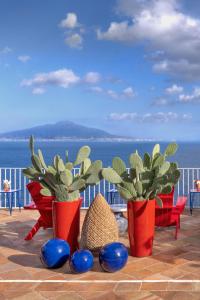 tre vasi rossi con piante su un balcone di Maison La Minervetta a Sorrento