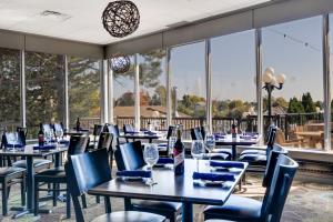 a restaurant with tables and chairs and windows at Holiday Inn Hotel Peterborough Waterfront, an IHG Hotel in Peterborough