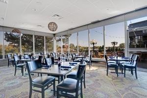 a dining room with tables and chairs and large windows at Holiday Inn Hotel Peterborough Waterfront, an IHG Hotel in Peterborough