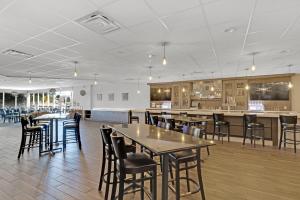 a restaurant with tables and chairs and a bar at Holiday Inn Hotel Peterborough Waterfront, an IHG Hotel in Peterborough