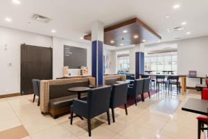 un restaurante con mesas y sillas y un bar en Holiday Inn Express Hotel & Suites-Edmonton South, an IHG Hotel, en Edmonton