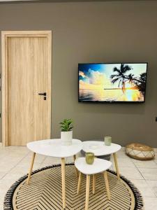 sala de estar con 2 mesas y TV en la pared en Anesis Comfort Nature Living, 