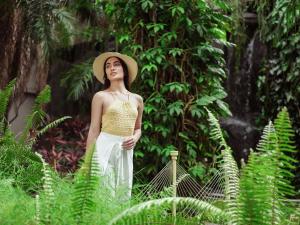 a woman wearing a hat standing in a garden at Taj Krishna in Hyderabad