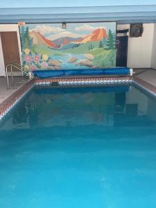 - une piscine avec un mur peint dans l'établissement Garden of the Gods Motel, à Colorado Springs