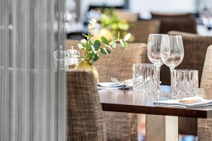 une table en bois avec des verres et un vase sur elle dans l'établissement Best Western Plus Park Globetrotter Copenhagen Airport, à Copenhague