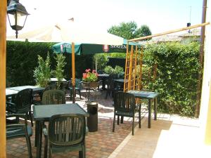 un patio extérieur avec des tables, des chaises et un parasol dans l'établissement Locanda Canareggio, à San Biagio di Callalta