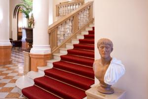 un escalier doté d'une statue d'un buste. dans l'établissement Parkhotel 1901 Mannheim, à Mannheim