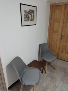 two chairs sitting in a room with a door at Romansa in Dušanovac (historical)