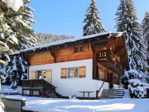 una cabaña de madera en la nieve con una mesa de picnic en Chalet Chalet Le Haut Pré by Interhome, en Villars-sur-Ollon