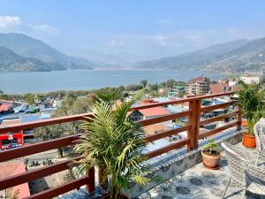 balkon z widokiem na wodę w obiekcie Pokhara Alpine and Springs w mieście Pokhara