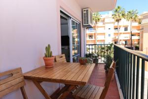 een balkon met een houten tafel en banken bij B95 - Casa Melo Apartment in Praia da Luz in Luz