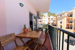 een balkon met een houten tafel en banken bij B95 - Casa Melo Apartment in Praia da Luz in Luz