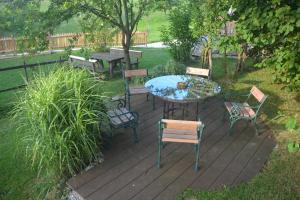 une terrasse en bois avec une table et des chaises. dans l'établissement Bio-Bauernhof Haunschmid, à Ardagger Markt