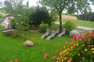 une rangée de chaises blanches dans une cour fleurie dans l'établissement Bio-Bauernhof Haunschmid, à Ardagger Markt