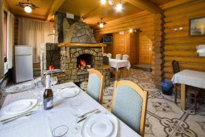 une salle à manger avec une table et une cheminée dans l'établissement Садиба У Василини та Романа, à Bukovel