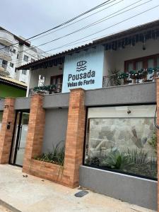 un edificio con un cartel que lee possada espera a los turistas en Pousada Velas do Forte, en Cabo Frío