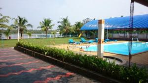 een zwembad met blauwe stoelen in een resort bij Blue Waters Cherai in Cherai Beach