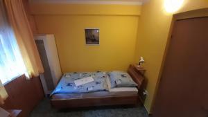 Dormitorio pequeño con cama en habitación amarilla en Rybí Dům, en Kocobedz