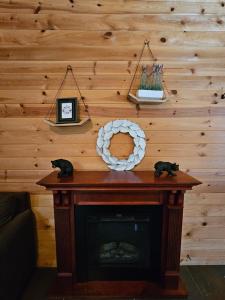 a fireplace in a living room with a wooden wall at Honey Bear Haven Suite 5 in Eureka Springs