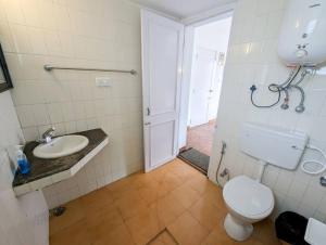 een badkamer met een toilet en een wastafel bij Bohemian Hideaway - Vintage Vibe 3BHK Villa in Kodaikānāl