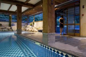 uma mulher está ao lado de uma piscina em Les Grands Montets Hotel & Spa em Chamonix-Mont-Blanc