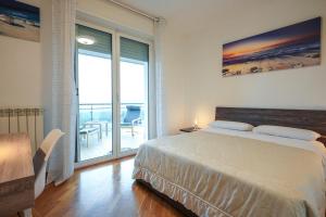 ein Schlafzimmer mit einem Bett und einem Balkon in der Unterkunft Nuvola Apartment Fiumicino Easy Self check-in in Fiumicino