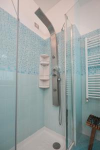 ein Bad mit einer Dusche und blauen Fliesen in der Unterkunft Nuvola Apartment Fiumicino Easy Self check-in in Fiumicino