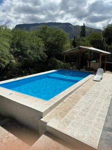 una gran piscina azul junto a una casa en EL PEDREGAL Casa en Cafayate, en Cafayate