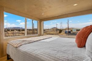 1 dormitorio con cama y ventana grande en Tiny home near Grand Canyon sleeps 5, epic views!, en Flagstaff