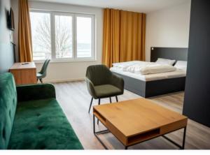 1 dormitorio con cama, sofá y mesa en Hotel Central Vis a Vis, en Mainz