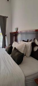 a bed with four pillows and a headboard at ZiFa Mandalika in Kuta Lombok