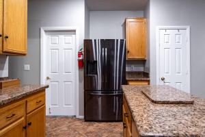 - un réfrigérateur en acier inoxydable dans une cuisine avec des placards en bois dans l'établissement 5BR 3BA Family friendly entire home w pool, spa, games, tvs, and more, à Las Vegas