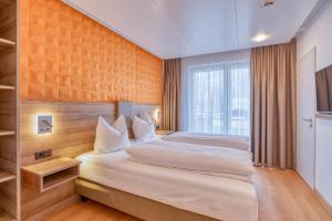 een slaapkamer met een bed en een groot raam bij WESTSIDE Hotel in München