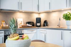 - une cuisine avec un bol de fruits sur une table dans l'établissement Seehuus Duhnen Apartments, à Cuxhaven