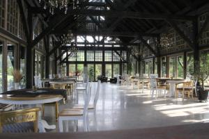 a dining room with tables and chairs and windows at Chill Inn in Bernāti